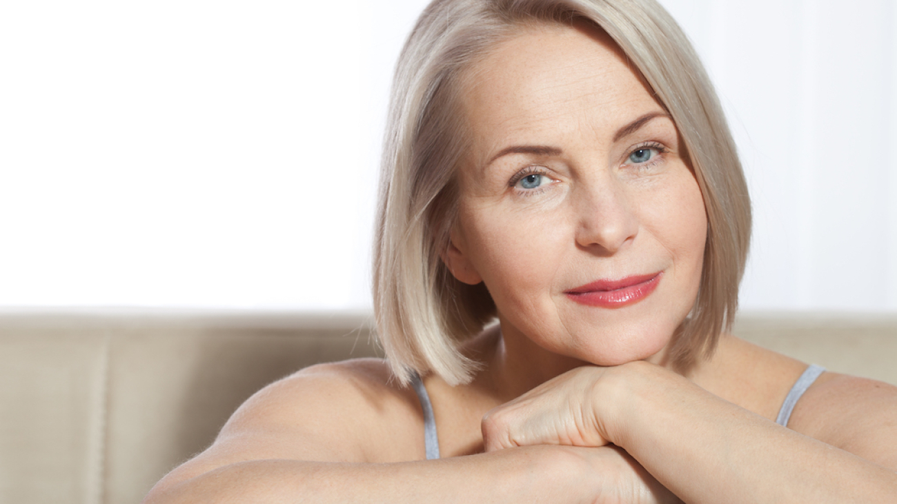 Beauty Woman with perfect skin Portrait. Beautiful middle-aged blonde woman shows off her perfectly well-groomed face. Plastic surgery and collagen injections. Macro face. Selective focus on face. Realistic images with their own imperfections.