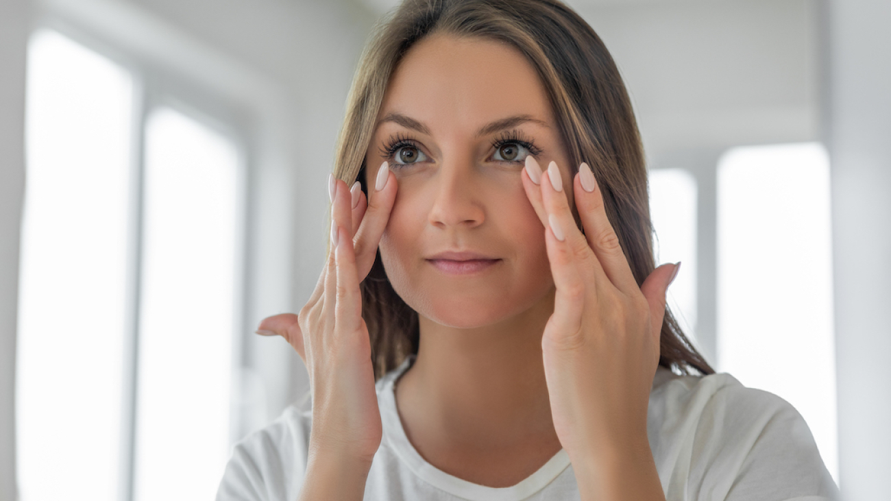 Applying moisturizing cream on under eye skin